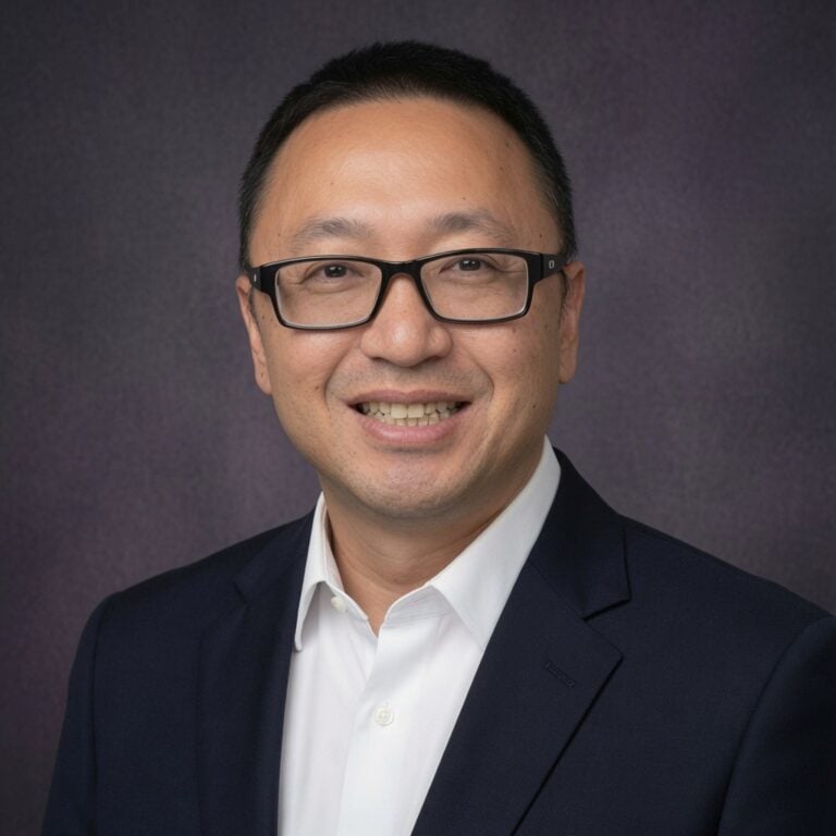 Close-up of a smiling businessman wearing glasses and a suit, representing professionalism and confidence.